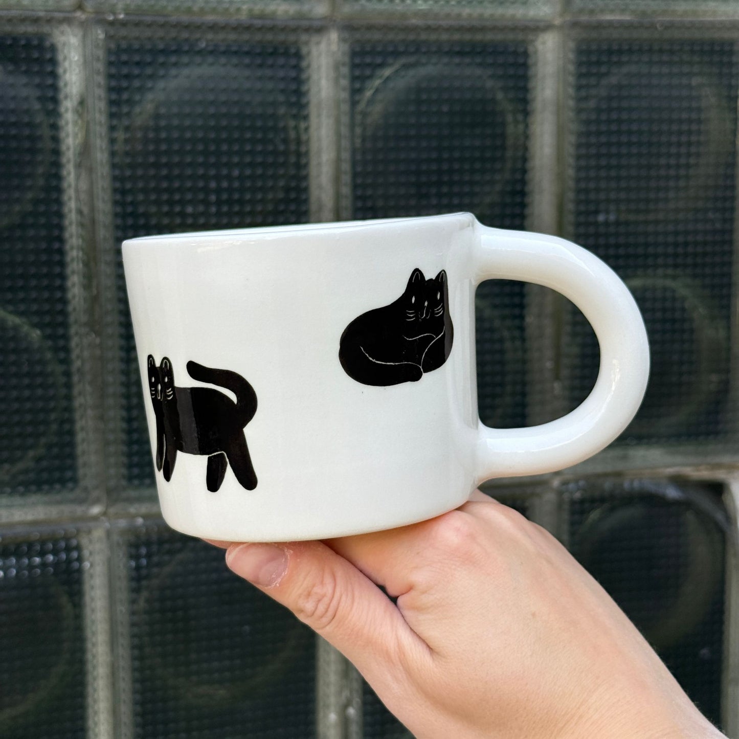 Kubek z małymi czarnymi kotkami