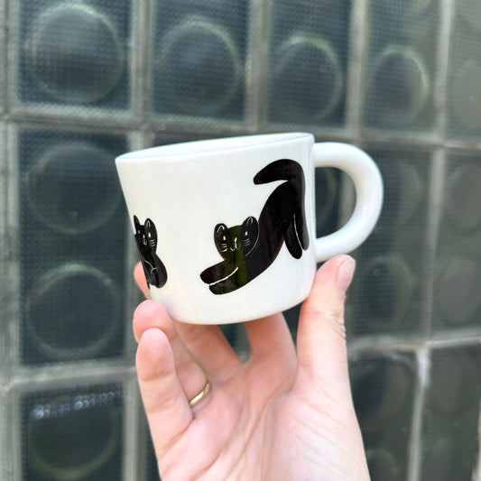 Kubek z małymi czarnymi kotkami